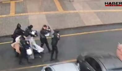 Fırtınada yürüyemeyen anne ve bebeğinin imdadına polis kalkanı yetişti