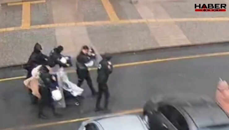 Fırtınada yürüyemeyen anne ve bebeğinin imdadına polis kalkanı yetişti